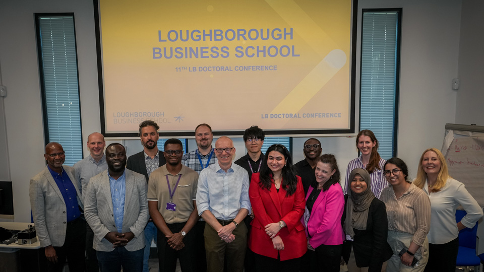 Group of people standing in front of a screen displaying 